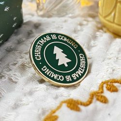 Christmas is coming - text with a Christmas tree image on a round pin badge