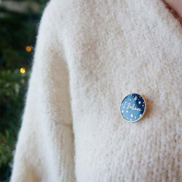 I believe - Christmas themed text on a round pin badge