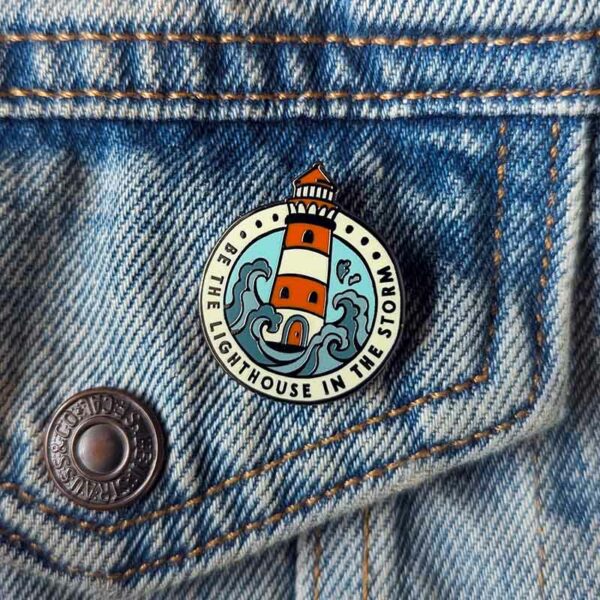 Be The Lighthouse In The Storm - round lighthouse pin badge on a denim jacket